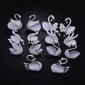 Detailed closeup view of silver crystal cat-eye swan brooches for stylish women daily accessories.