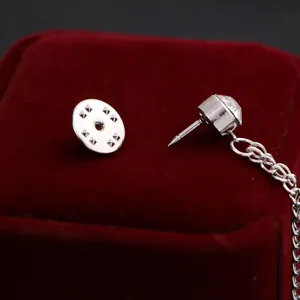 Detalle broche cadena pedrería plateada, elegante accesorio joyería solapa para hombre.