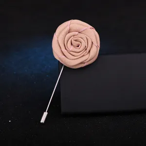 Broche fleur rose en tissu fait main pour costume homme vue de détail, accessoire élégant.