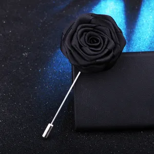 Détail épingle de revers rose en tissu, broche fleur noire avec longue tige d'aiguille argent.