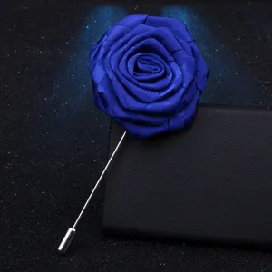 Gros plan d'une broche rose en tissu bleu vif avec une longue épingle en métal argenté.