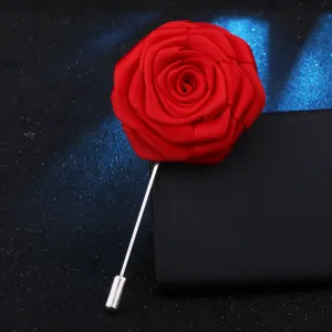 Gros plan d'une épingle de revers rose en tissu rouge faite à la main avec aiguille.