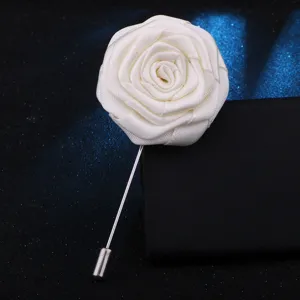 Gros plan d une broche fleur de rose en tissu blanc artisanal avec une longue aiguille.