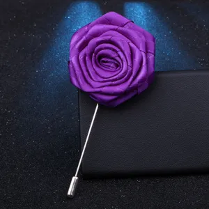 Gros plan détail de l'élégante broche fleur de rose en tissu violet avec longue tige.