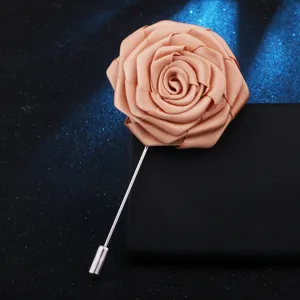 Gros plan sur l'élégante épingle de revers rose en tissu champagne pour costume homme.