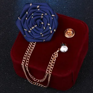Nahaufnahme einer handgefertigten dunkelblauen Stoff-Rosennadel mit Kette und Strass.