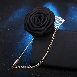 Élégante épingle de revers rose en tissu noir avec chaîne dorée pour costumes d'hommes.