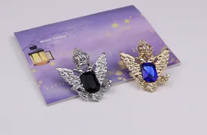 Nahaufnahme der Retro Doppeladler Krone Brosche mit glitzernden Strasssteinen und Edelsteinen.