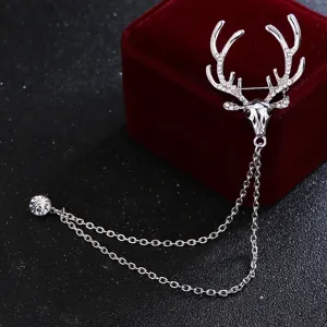 Gros plan détaillé d'une broche cerf argentée avec bois en cristaux et chaînes pendantes.