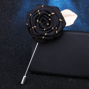 Black ribbon rose lapel pin with gold leaf detail, elegant accessory for formal wear.