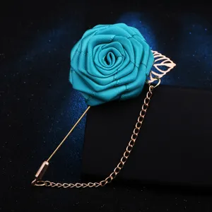 Broche fleur rose en tissu bleu avec chaine doree et feuille, accessorio de costume elegant.