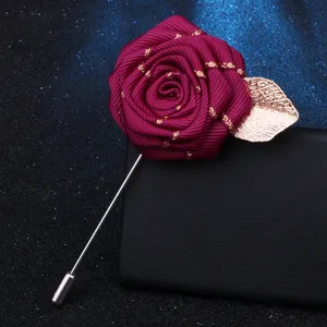 Handcrafted ribbon rose brooch with gold leaf detail, elegant lapel pin accessory for outfits.