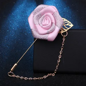 Nahaufnahme einer handgefertigten rosa Stoffrosen Anstecknadel mit langer Nadel und Kette.