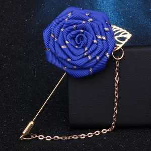 Detailaufnahme der eleganten blauen Stoffrosen Brosche mit goldener Kette und Blatt-Anstecker.