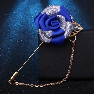 Nahaufnahme einer handgefertigten blauen Stoffblumenbrosche mit langer goldener Nadel.