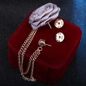 Nahaufnahme einer handgefertigten Stoff-Band-Blumen-Reversnadel mit Strass-Quasten-Kette.
