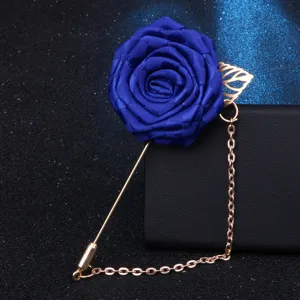 Vue rapprochée détaillée de la broche rose en tissu bleu roi avec chaîne suspendue élégante.