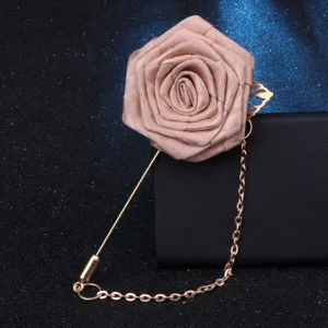 Gros plan sur une broche fleur en tissu exquise avec longue épingle et chaîne suspendue.