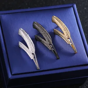 Detail view of elegant alloy feather brooch pins in silver, black and gold colors for suits.
