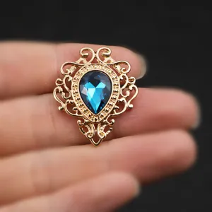 Nahaufnahme einer vintage blauen Kristall Edelstein Brosche mit goldener hohler Spitze.