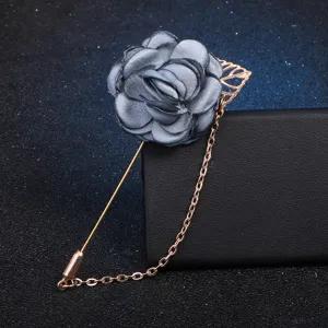 Elegant grey fabric camellia flower lapel pin featuring a gold-toned tassel chain.