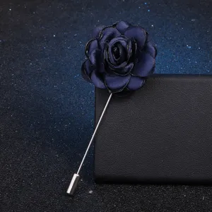 Vue détaillée d'une élégante broche épingle à fleur de camélia en tissu bleu foncé chic.