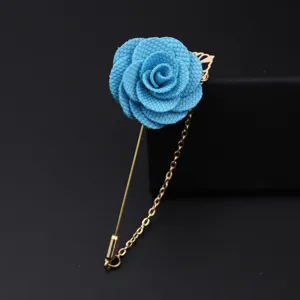 Detailaufnahme einer blauen Stoffrosenbrosche mit filigranem Langnadel- und Kettendesign.