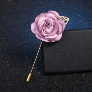Detailed view of elegant fabric rose flower brooch with gold leaf and long stick pin accessory.