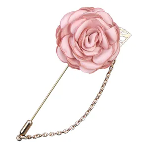 Elegant pink fabric camellia flower brooch with a delicate metal tassel chain pin.