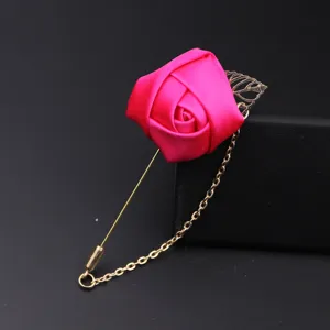 Nahaufnahme der pinken Satin Rosen Anstecknadel mit goldener langer Nadel und Kettenzubehör.