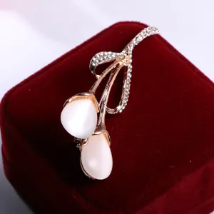 Spilla a tulipano placcata in oro con pietra occhio di gatto bianca e strass per donne.