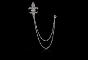 Primo piano dettagliato della spilla giglio in strass argento con doppie catene pendenti.