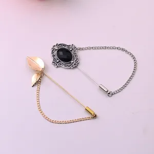 Close-up detail of retro metal lapel pins, featuring silver and gold brooch designs with chains.