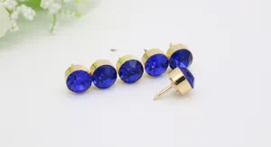 Nahaufnahme glänzender blauer Strass-Reversnadeln mit goldfarbener Metallbasis und scharfen Pins für Kleidung.