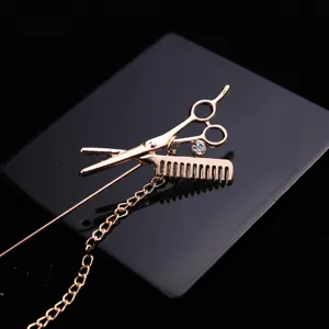 Gold scissor comb brooch with chain and rhinestone, men's personalized fashion accessory.