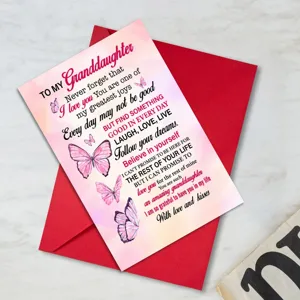 Vue de détail en gros plan de la carte de vœux papillon rose et de l'enveloppe rouge.