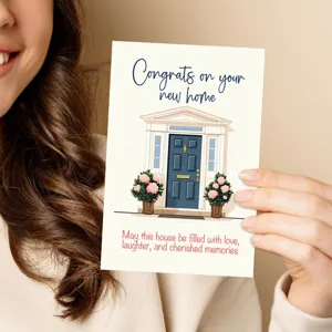 Close-up of a housewarming greeting card with a lovely home illustration and warm wishes.