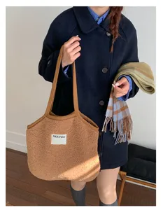Gros plan sur le sac cabas duveteux marron confortable avec deux anses et une étiquette.