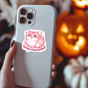 Close-up detail of a cute pink cat sticker with Russian text on a phone case.