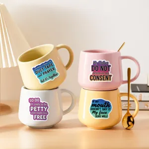 Set von Keramik-Kaffeetassen mit lustigen englischen Slogans und Löffel für Küche.