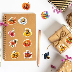 Detailed shot of cute watercolor bee and ladybug stickers arranged on a notebook and gift box.