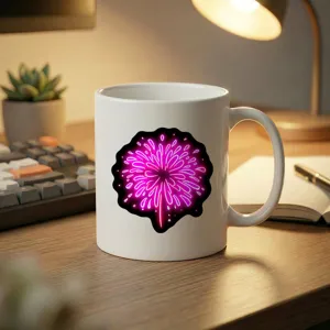 White ceramic coffee mug with vibrant neon pink firework print on cozy desk setup.
