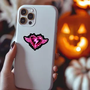 Gros plan détaillé de l'autocollant cœur rose gothique sur une coque de téléphone blanche.