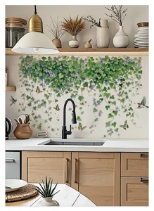 Vue de detail du sticker mural de vigne et plante verte fraiche dans la cuisine.