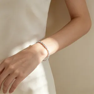 Elegante bracciale tennis in argento con zirconi scintillanti sul polso di una donna.