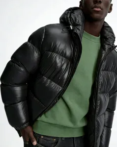 Close-up view of a men's shiny black hooded puffer jacket featuring a quilted warm design.