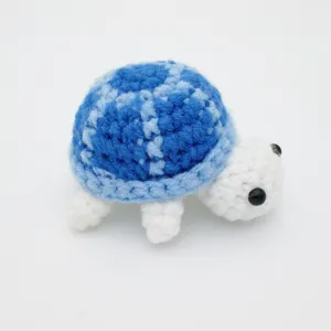 Nahaufnahme einer handgefertigten blau-weißen Häkelschildkröte Amigurumi Textur