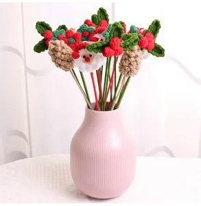 Hand-knitted Christmas bouquet with Santa Claus, pinecones and berries in a pink vase.