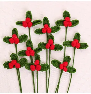 Close-up of handmade crochet Christmas holly bouquet with red berries