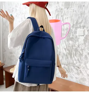 Detailansicht eines dunkelblauen Segeltuchrucksacks, getragen von einem Modell im Innenbereich